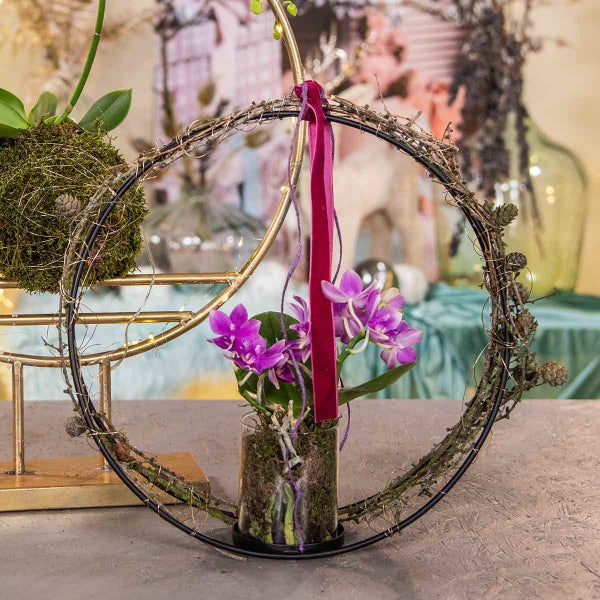 Dekoration mit Orchideen in einem runden Rahmen und einem Glasgefäß