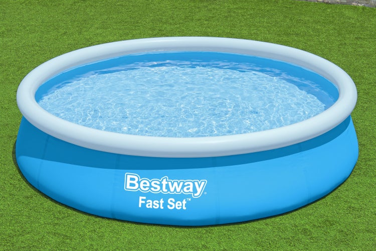 Rundes blaues Bestway Fast Set Aufstellbecken auf einer Rasenfläche, gefüllt mit Wasser und einem weißen aufblasbaren Ring.