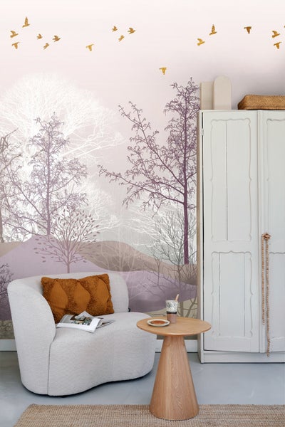 Wohnzimmer mit Sessel, Beistelltisch und Wandtapete mit Baummotiv