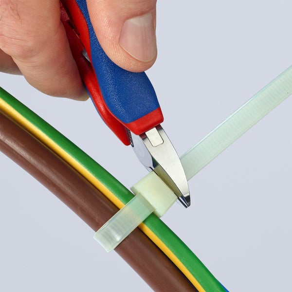 Eine Hand schneidet einen Kabelbinder mit einem Seitenschneider an einem Kabel ab.