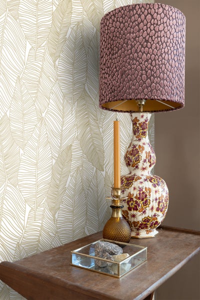 Dekoratives Interieur mit gemusterter Tapete, Tischlampe und Kerze