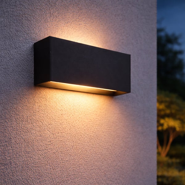 Moderne rechteckige Außenwandleuchte in Schwarz mit Lichtaustritt nach oben und unten an einer strukturierten Fassade.