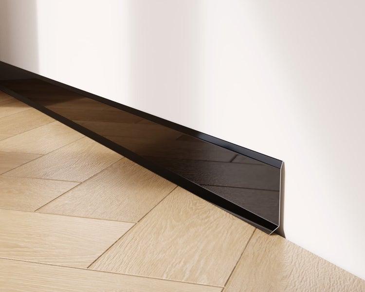 Schwarze Sockelleiste an einer Wand über einem Holzboden