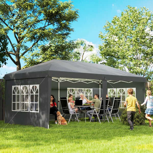 Großes Partyzelt in Anthrazit mit Rundbogenfenstern im Garten, Personen sitzen an einem Tisch unter dem Pavillon.