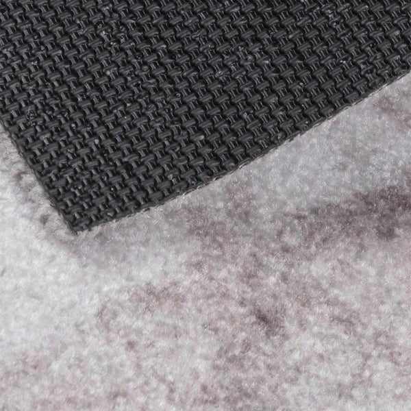 Detailansicht eines Teppichs mit rutschfester Unterseite und flauschiger Oberseite.
