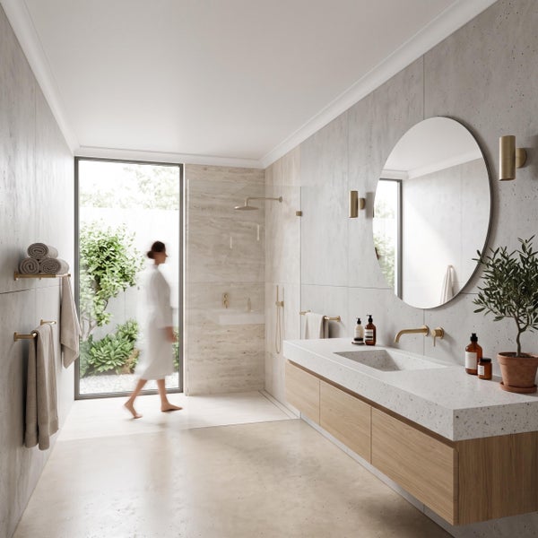 Modernes Badezimmer mit wandhängendem Waschtisch, rundem Spiegel, bodengleicher Dusche und Blick in einen begrünten Gartenbereich.