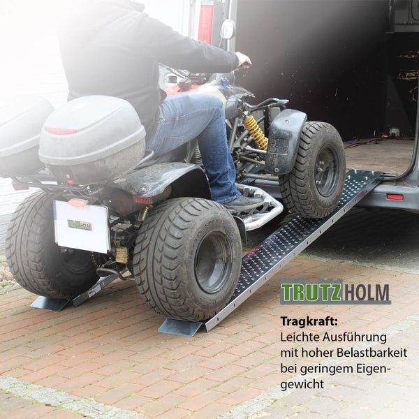 Quad wird mit einer Auffahrrampe in einen Transporter verladen.