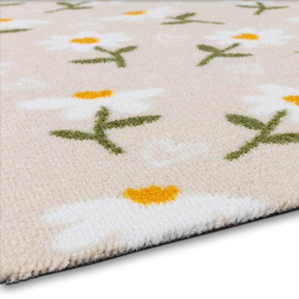 Weicher Teppich mit floralem Gänseblümchen-Muster und kleinen weißen Herzen auf beigem Untergrund.