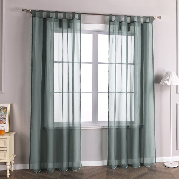 Raumszene mit transparenten Gardinen mit Schlaufenaufhängung vor einem Fenster