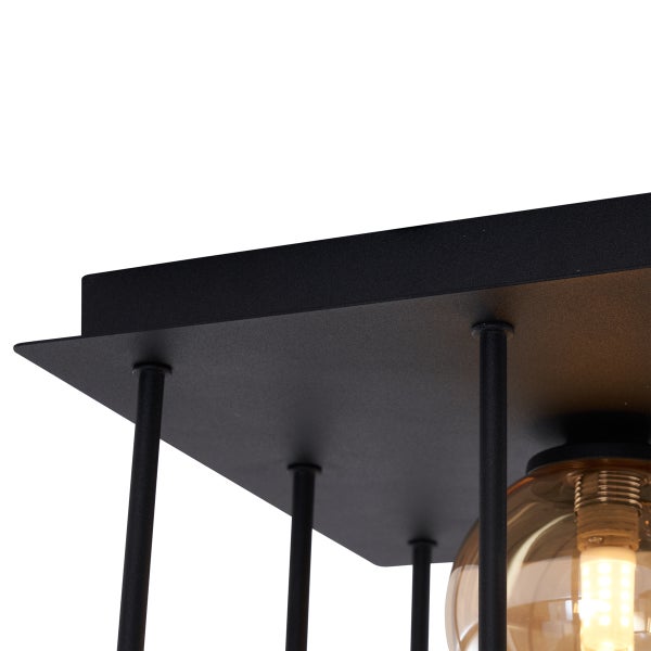 Detailansicht einer Deckenleuchte mit Metallgestell und bernsteinfarbenem Glasschirm