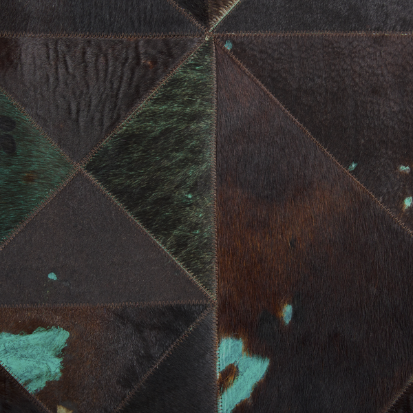 Patchwork-Teppich aus Kuhfell mit geometrischen Mustern und sichtbaren Zickzack-Nähten.