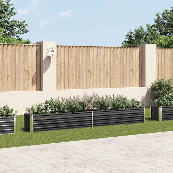 Gartenszene mit schwarzen Hochbeeten und bepflanztem Garten