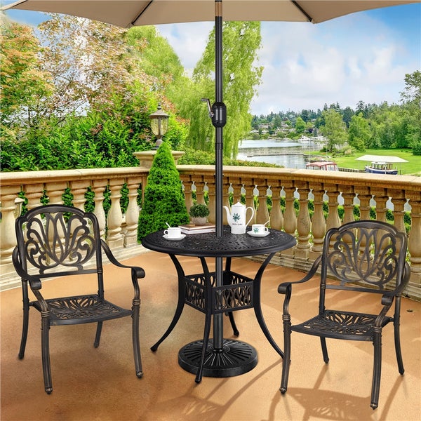 Gartensitzgruppe mit Tisch, zwei Stühlen und Sonnenschirm auf einer Terrasse mit Blick auf einen See