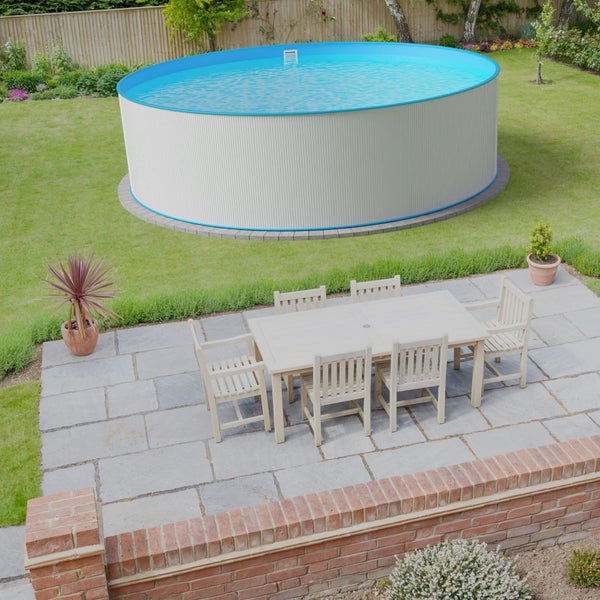 Gartenansicht mit rundem Pool, Esstisch und Stühlen auf einer Steinterrasse.