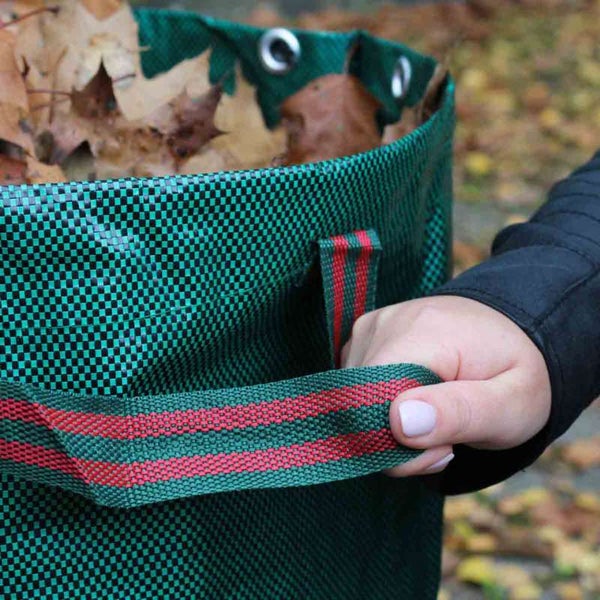 Gartensack gefüllt mit Laub, gehalten von einer Hand