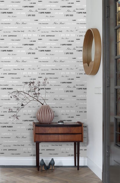 Dekoratives Interieur mit Kommode, Vase und Wandhaken vor einer Wand mit Stadtnamen Tapete.