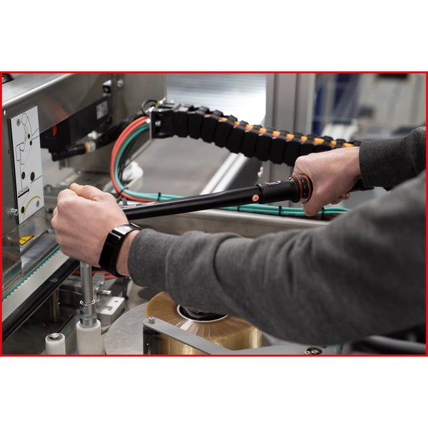 Ein Mann benutzt einen Drehmomentschlüssel an einer Maschine.