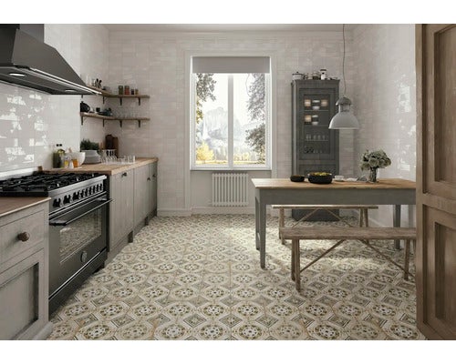 Helle Küche mit gemusterten Fliesen, Esstisch und Küchenzeile.