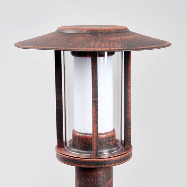 Moderne Außenstandleuchte mit rostfarbenem Metalldach und weißem Diffusor in einem Glaszylinder.