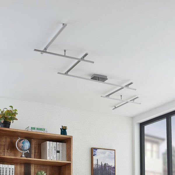 Moderne LED-Deckenleuchte aus Metall mit geometrischem Zickzack-Design in einem hellen, organisierten Raum mit Bücherregal.