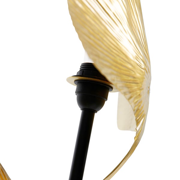 Detail einer Stehlampe mit goldenem Lampenschirm und schwarzem Lampenfuß