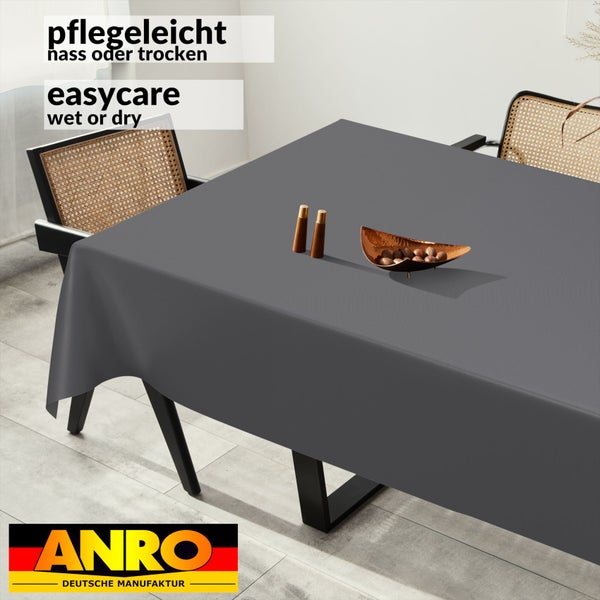 Graue, pflegeleichte Tischdecke auf einem Esstisch mit Stühlen, nass oder trocken abwischbar. ANRO Deutsche Manufaktur Logo.