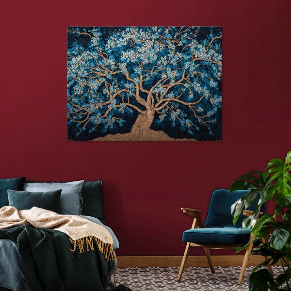 Schlafzimmer mit Bett, Sessel und Wandbild mit Baumdarstellung