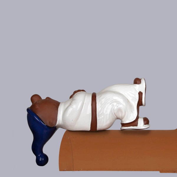 Firstfigur schlafender Zwerg aus glasierter Keramik mit blauem Hut und weißem Gewand.