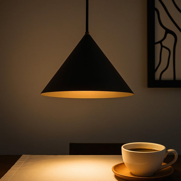 Schwarze Hängelampe über einem Tisch mit einer Tasse Kaffee