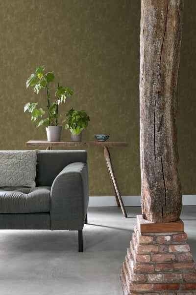 Wohnzimmer mit Sofa, Tisch, Pflanzen und Holzsäule auf Ziegelsteinsockel