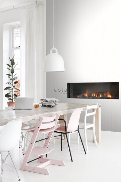 Helles Esszimmer mit Holztisch, Stühlen, Zimmerpflanze, Lampe und Kamin