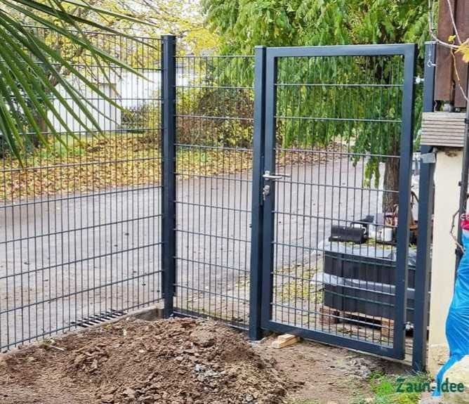 Gartentor mit Doppelstabmattenzaun und Metallpfosten in einem hellen, geräumigen Garten. Zaun-Idee Logo.