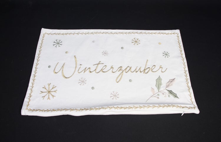 Dekokissen mit der Aufschrift Winterzauber und Schneeflockenmuster
