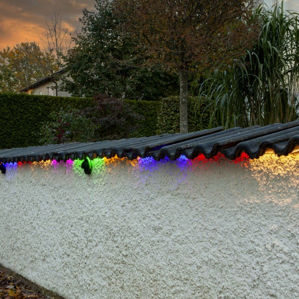 Bunte Lichterkette beleuchtet eine Mauer im Außenbereich
