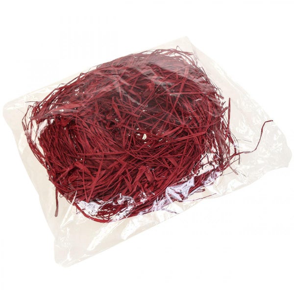 Rotes dekoratives Füllmaterial aus Holzwolle in einem transparenten Kunststoffbeutel.