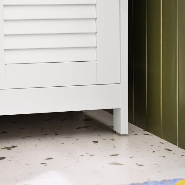 Detailaufnahme eines weißen Badezimmerunterschranks mit Lamellentüren und Füßen