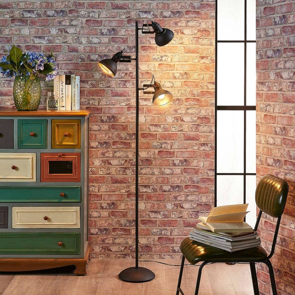 Stehleuchte mit drei Strahlern neben Kommode und Stuhl