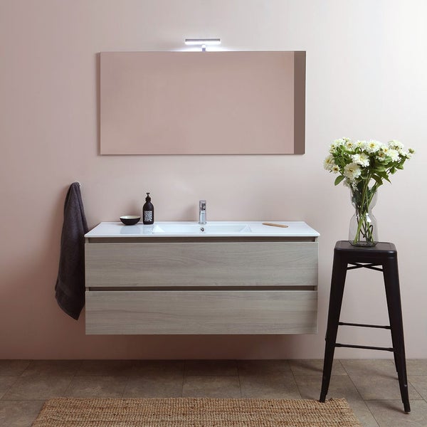 Modernes Badezimmer mit Waschbeckenunterschrank, Spiegel und Beleuchtung für eine helle und stilvolle Atmosphäre.