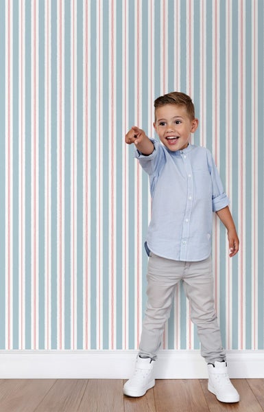 Zimmer mit gestreifter Tapete und lachendem Kind, das in die Kamera zeigt