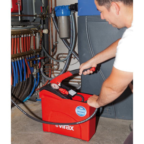 Ein Mann bedient eine Druckpumpe von Virax in einem Installationsraum