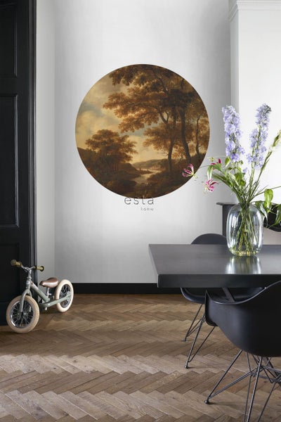Wohnzimmer mit runder Wanddekoration mit Landschaftsmotiv über einem Kinderfahrrad und einem Esstisch