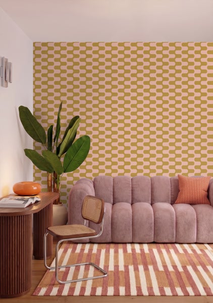 Vliestapete mit geometrischem Wellenmuster im Retro-Stil in einem Wohnzimmer mit Sofa, geriffeltem Holztisch, Korbstuhl und Zimmerpflanze.
