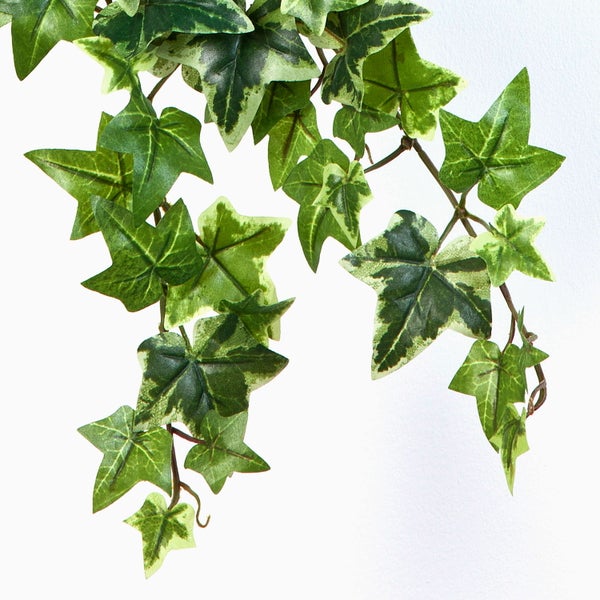 Künstlicher Magnolienzweig mit einer Knospe und einem braunen Fruchtstand