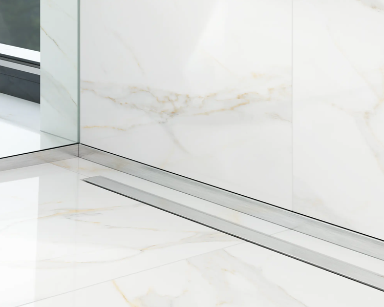 Duschrinne aus Edelstahl in einem Badezimmer mit Fliesen in Marmoroptik an Wand und Boden.