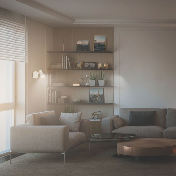 Modernes Wohnzimmer mit weißem Wandstrahler über einem grauen Sofa und Holzregalen mit Büchern und Dekoration.