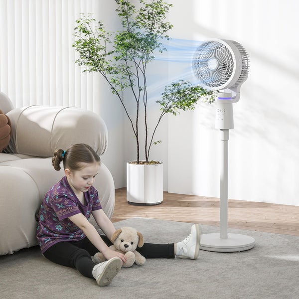 Weißer Standventilator im hellen, modernen Wohnzimmer neben einer Zimmerpflanze und einem Kind, das auf dem Teppich spielt.