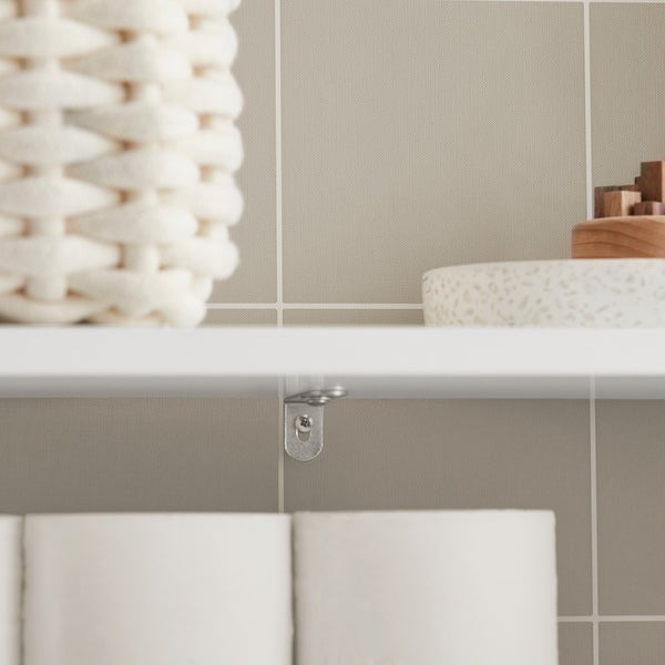 Detailansicht eines weißen Regals mit Halterung und Dekoration