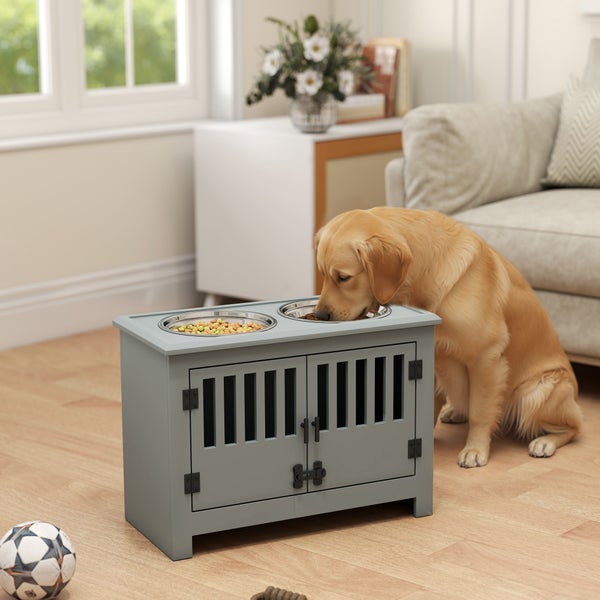 Graue Hundefutterstation mit zwei Edelstahlnäpfen und Hundehütte im Möbelstil in einem hellen Wohnzimmer mit einem Golden Retriever.