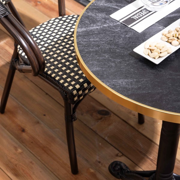 Dreiteiliges Bistro-Set bestehend aus einem runden Tisch mit Marmordekor und zwei schwarz-beige geflochtenen Stühlen im klassischen Design.