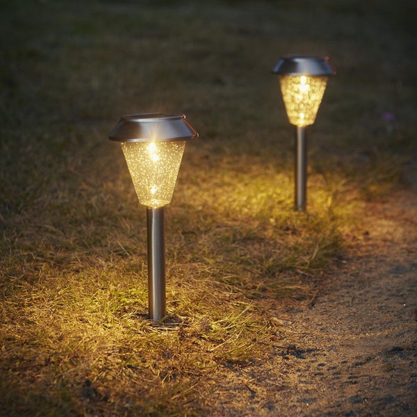 Zwei Solarleuchten im Garten beleuchten einen Weg.